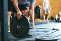 a man picking up a weight in the gym
