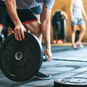 a man picking up a weight in the gym