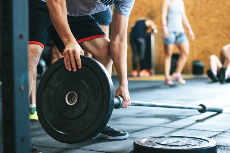 a man picking up a weight in the gym
